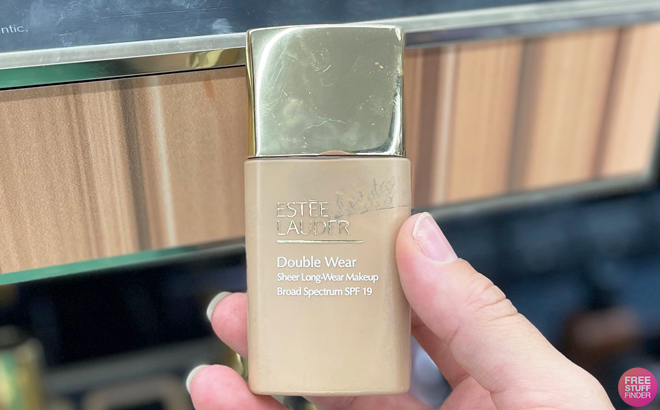 Hand Holding a Estee Lauder Double Wear Sheer Long Wear Foundation Hand Holding a Estee Lauder Double Wear Sheer Long Wear Foundation