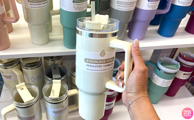 Hand Holding a Stainless Steel Insulated Tumbler in Cream Color