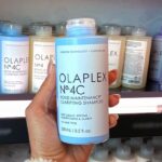 Hand holding Olaplex No 4C Bond Maintenance Clarifying Shampoo