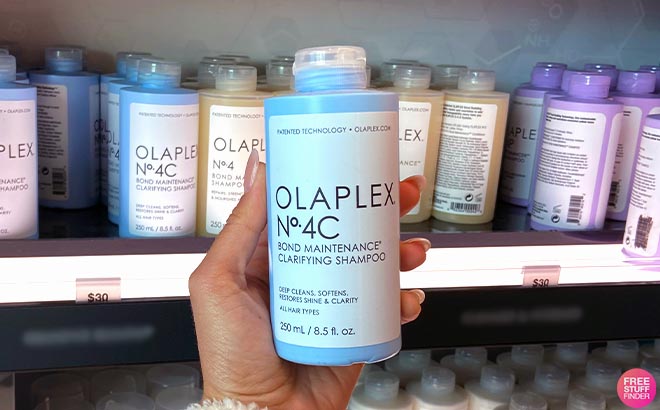 Hand holding Olaplex No 4C Bond Maintenance Clarifying Shampoo