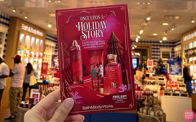 Hand holding one Bath and Body Works Christmas Pamphlet