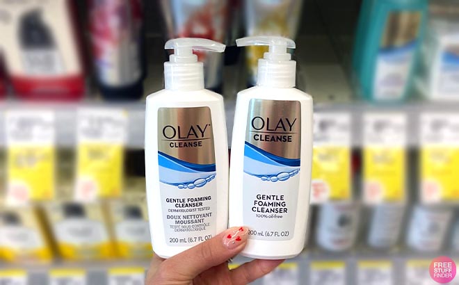 Hand holding two Olay Gentle Foaming Face Cleanser