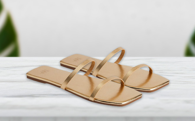 Metallic Faux Leather Sandals for Women in a Gold color on the Table