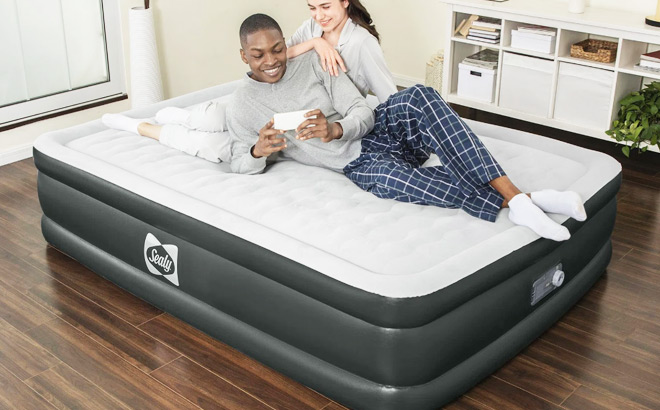 Smiling Couple Lying on Sealy Tritech Inflatable Air Mattress Bed