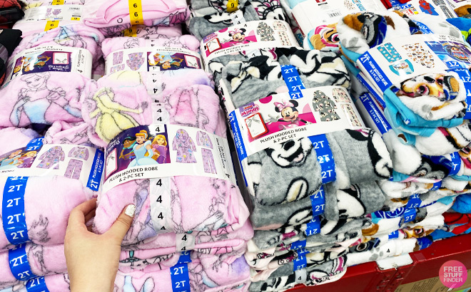 Woman Touching Disney 3 Piece Robe Pajama Sets on Store Shelf