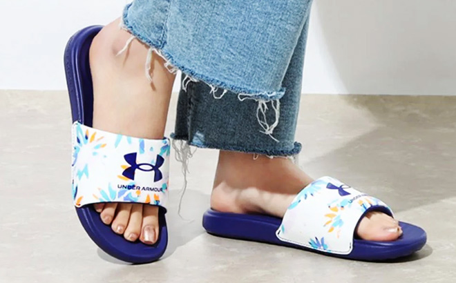 Woman is Wearing a Under Armour Ansa Graphic Slides in Sonar Blue color