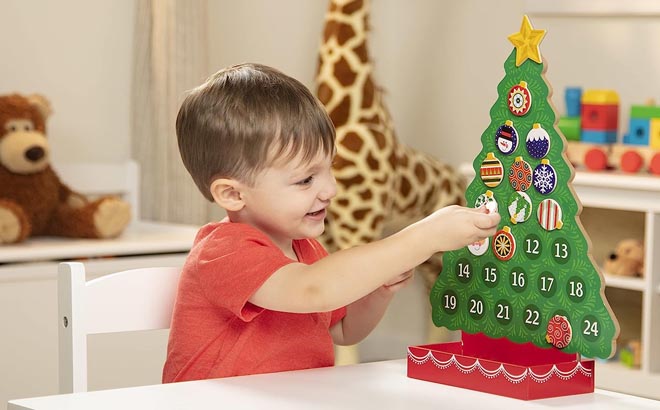 a Boy Playing with Melissa Doug Countdown to Christmas Wooden Advent Calendar