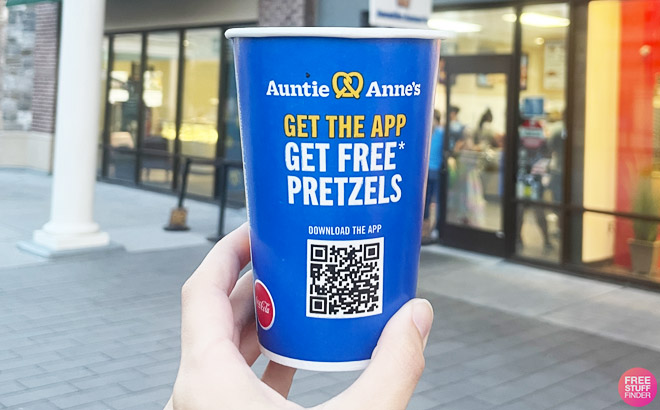 a Hand Holding an Auntie Annes Disposable Cup