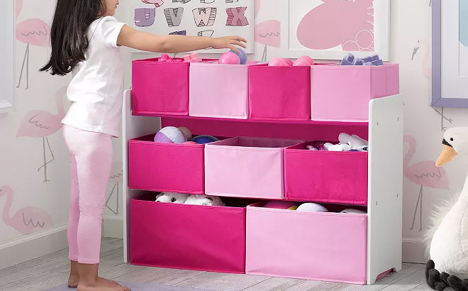 an Image of a Girl Getting a Toy from a Delta Children Deluxe Multi Bin Toy Organizer Bin