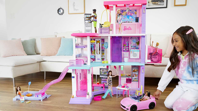 A Girl Playing with Barbie Deluxe Special Edition 60th DreamHouse Playset