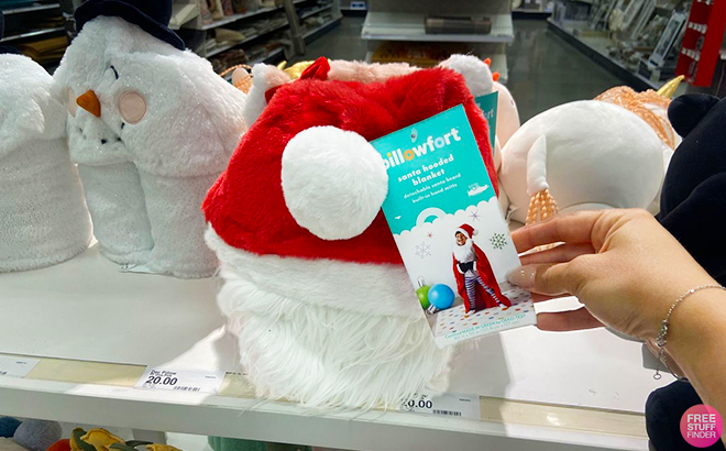 A Hand Holding Up the Santa Hat Pillowfort Christmas Blanket in Target