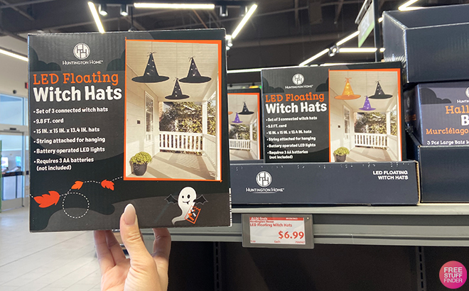 A Hand Holding a LED Floating Witch Hats on a Box