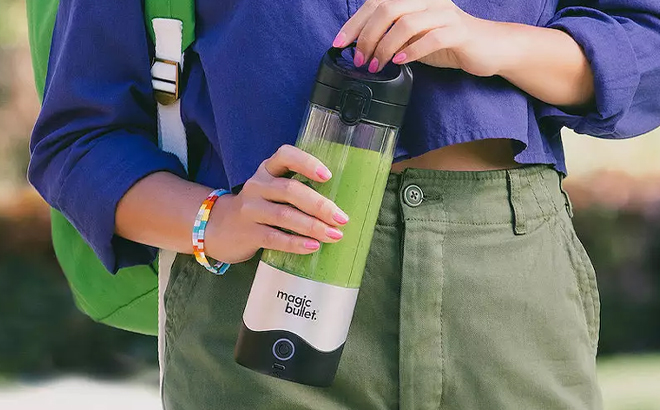 A Model Holding a Magic Bullet Portable Blender