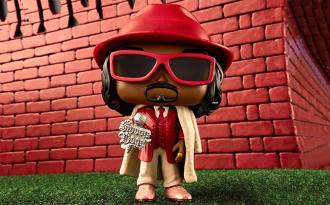 A Snoop Dogg Funko Pop with a Fur Coat on a Lawn A Snoop Dogg Funko Pop with a Fur Coat on a Lawn