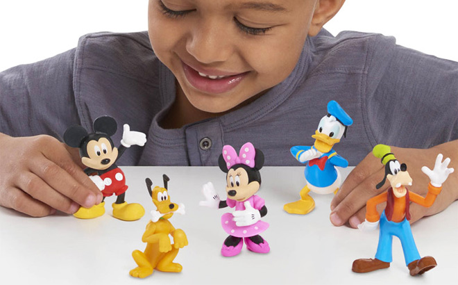Boy is Playing with Disney Mickey Mouse Collectible Figure Set on the Table
