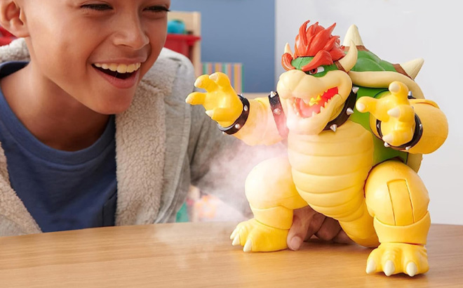 Boy is Playing with The Super Mario Bros Movie 7 Inch Feature Bowser Action Figure with Fire Breathing Effects on Table