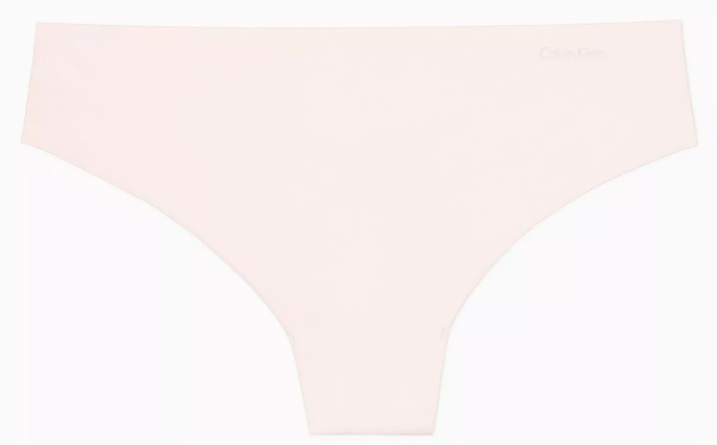 Calvin Klein Invisibles Thong in Nymphs Thigh Color on a Light Gray Background