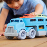 Child Playing with Green Toys Car Carrier in Blue