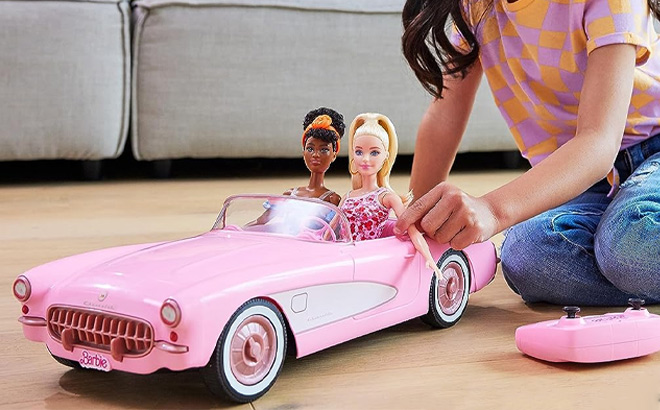 Girl is Playing with Hot Wheels RC Barbie Corvette and 2 Barbie Dolls