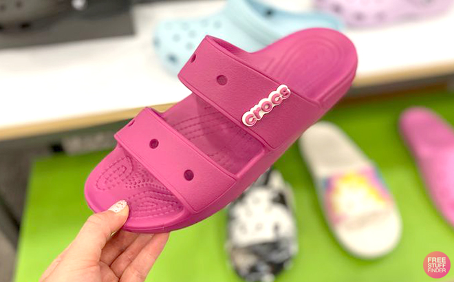 Hand Holding Crocs Classic Sandals in Pink Color