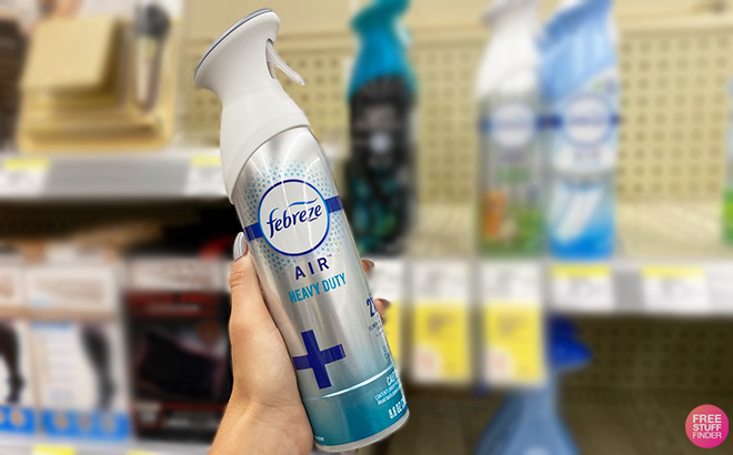Hand Holding Febreze Air Heavy Duty Refresher Spray in a Store Aisle