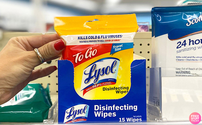 Hand Holding Lysol 15 Count Disinfecting Wipes on a Shelf