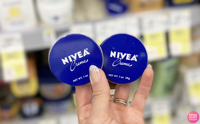 Hand Holding Nivea Moisturizing Cream Tins