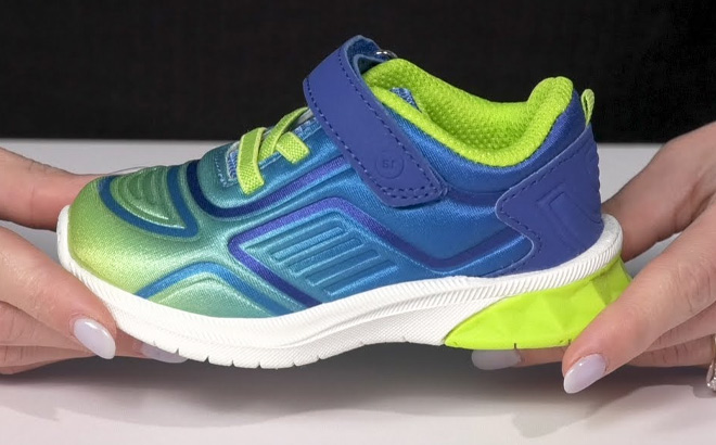 Hand Holding Stride Rite Chance Sneaker for Kids in Neon Green Color