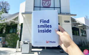Hand Holding Walgreens Photo Card Paper in Front of Walgreens Store