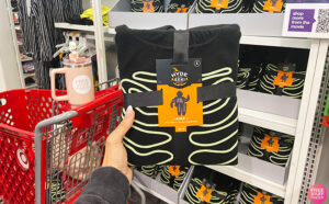 Hand Holding a Glow In The Dark Skeleton Halloween Matching Family Pajama in a Store Aisle