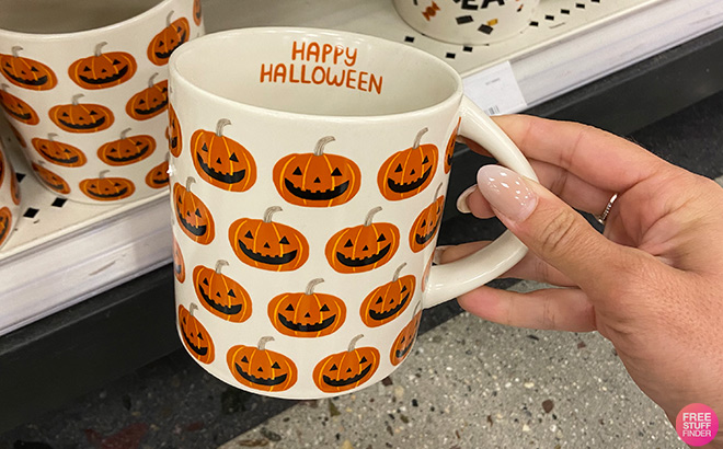 Hand Holding a Happy Halloween with Pumpkins 16 oz Drinkware in a Store Aisle