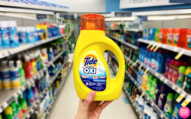 Hand Holding a Tide Simply Oxi Detergent in a Store Aisle