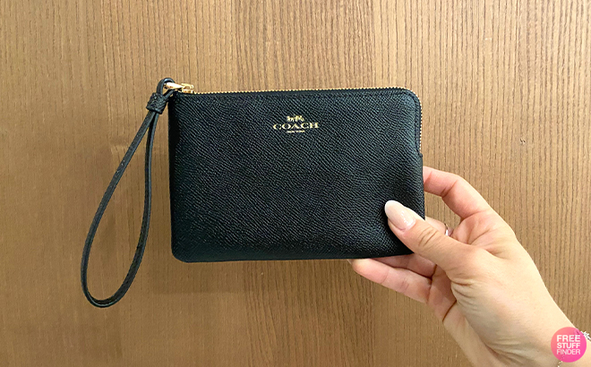 Hand Holding the Coach Outlet Corner Zip Wristlet in Black Color