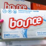 Hand holding one Bounce Free and Gentle Dryer Sheets 200 Count