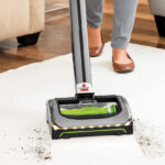 Lady Using Bissell AirRam Cordless Vacuum to Clean a Carpet