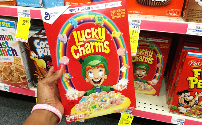 Person Holding a Box of General Mills Lucky Charms Cereal at CVS