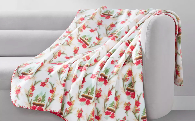 The Holiday Printed Fleece Throw Laid Out on a Couch