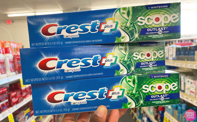 Woman Holding Three Crest Scope Toothpaste