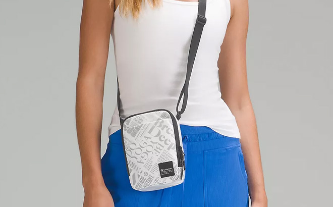 Woman is Wearing Lululemon Easy Access Crossbody Bag in Manifesto Print Style