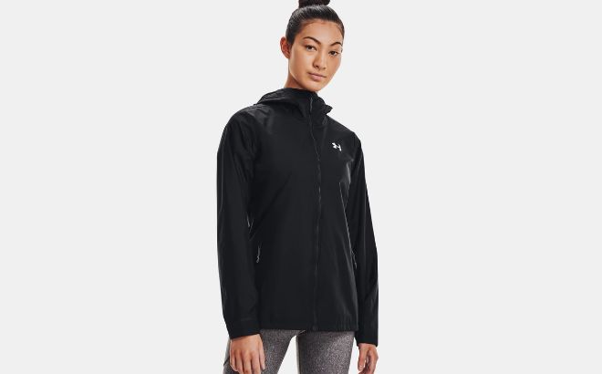 Woman is Wearing Under Armour Storm Forefront Rain Jacket in Black Ghost Gray Color