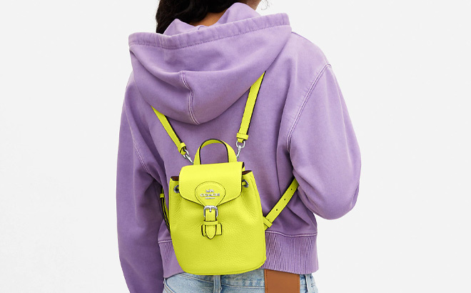 Woman is Wearing a Amelia Convertible Backpack in Bright Yellow Color