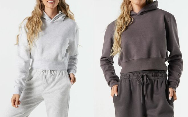 Woman is Wearing a Fleece Cropped Hoodie in Light Grey Color on the Left and in Dark Grey Color on the Right Woman is Wearing a Fleece Cropped Hoodie in Light Grey Color on the Left and in Dark Grey Color on the Right