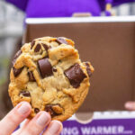A Graduate Holding a Classic Cookie from Insomnia Cookies