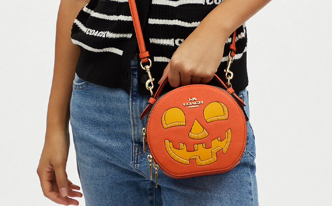 A Model Carrying a Coach Outlet Halloween Pumpkin Crossbody