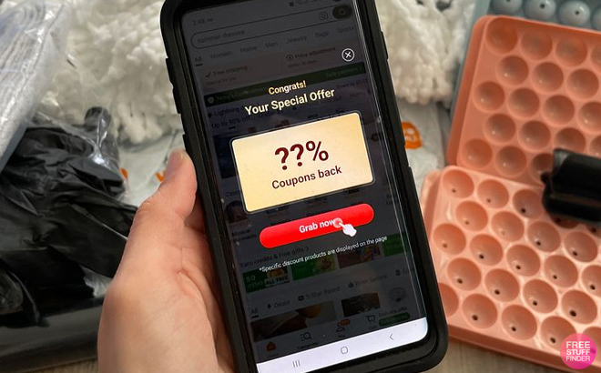 A Person Holding an iPhone with the Temu App Coupon Page Opened A Person Holding an iPhone with the Temu App Coupon Page Opened
