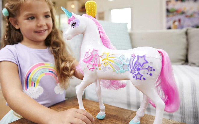 Girl is Playing with Barbie Dreamtopia Unicorn Toy