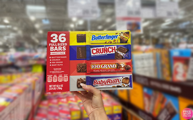 Hand Holding 36 Full Sized Bars Variety Pack in a Store Aisle