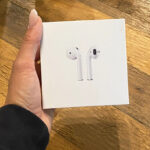Hand Holding Apple AirPods in a Box