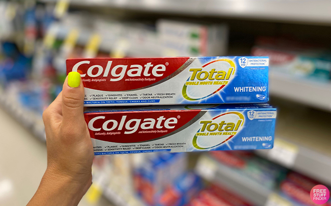 Hand Holding COlgate Total Whitening Toothpaste at Walgreens