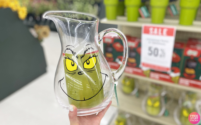 Hand Holding Grinch Glass Pitcher